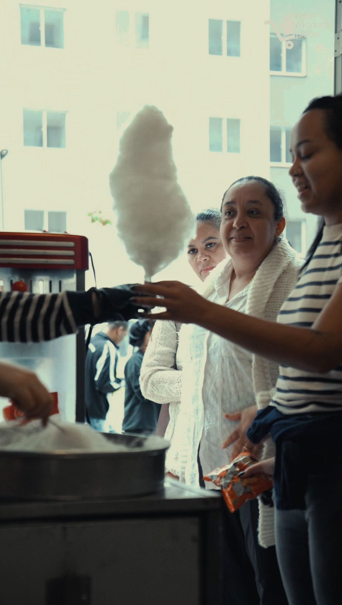 Algodão-doce sendo entregue a moradoras na inauguração