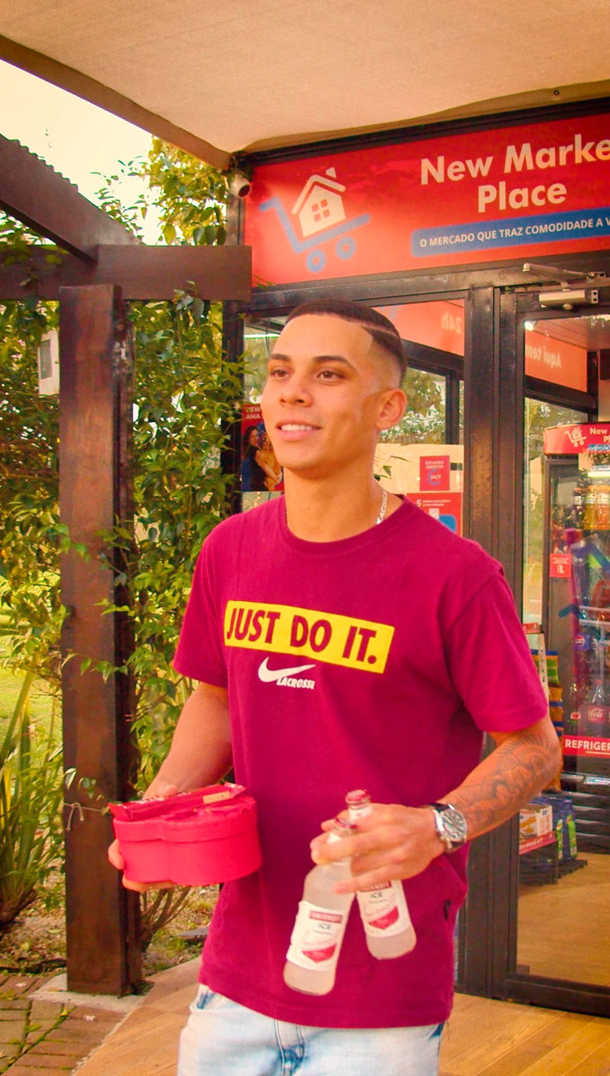 Jovem sai da loja com bebidas e um pote de sorvete nas mãos